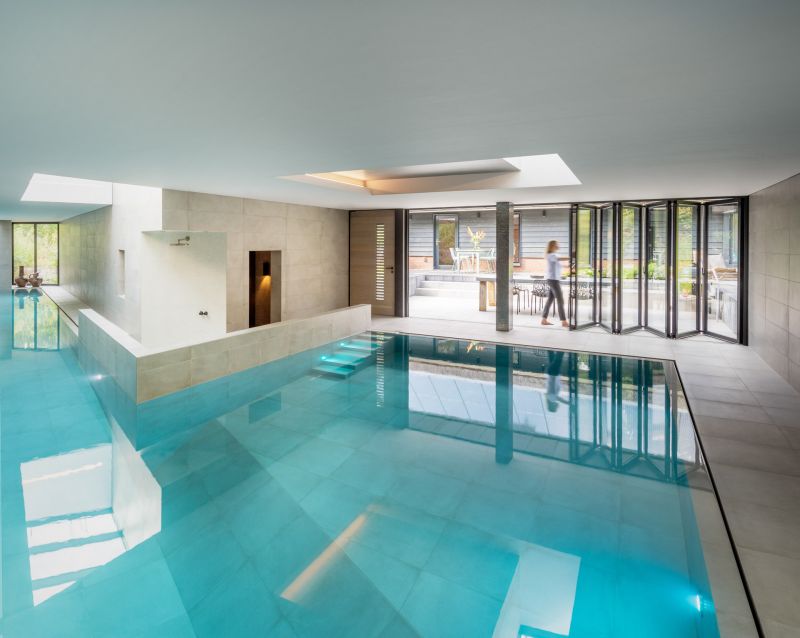 Schwimmbad zur Terasse hin, mit großen Glas-Faltwänden von Solarlux 